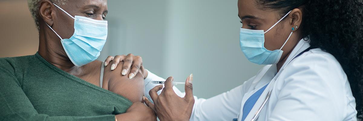 A health care provider gives a patient a vaccination