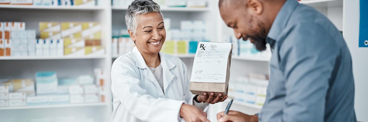 A woman pharmacist helping a male customer in a drug store