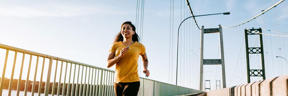 Woman jogging across bridge