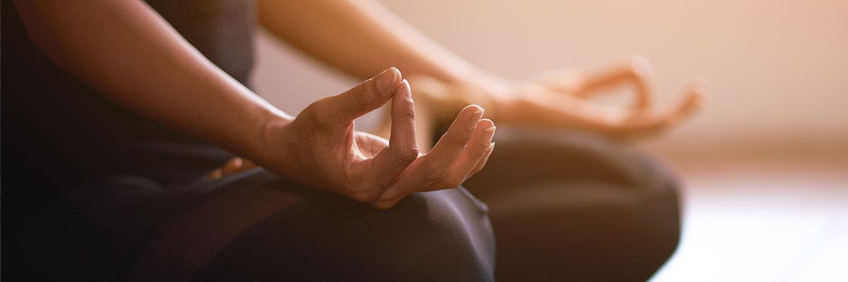 Close up of hands on knees of person meditating