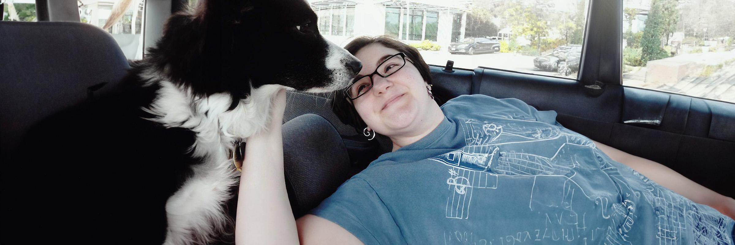 Photo of a person with her dog in a car. 