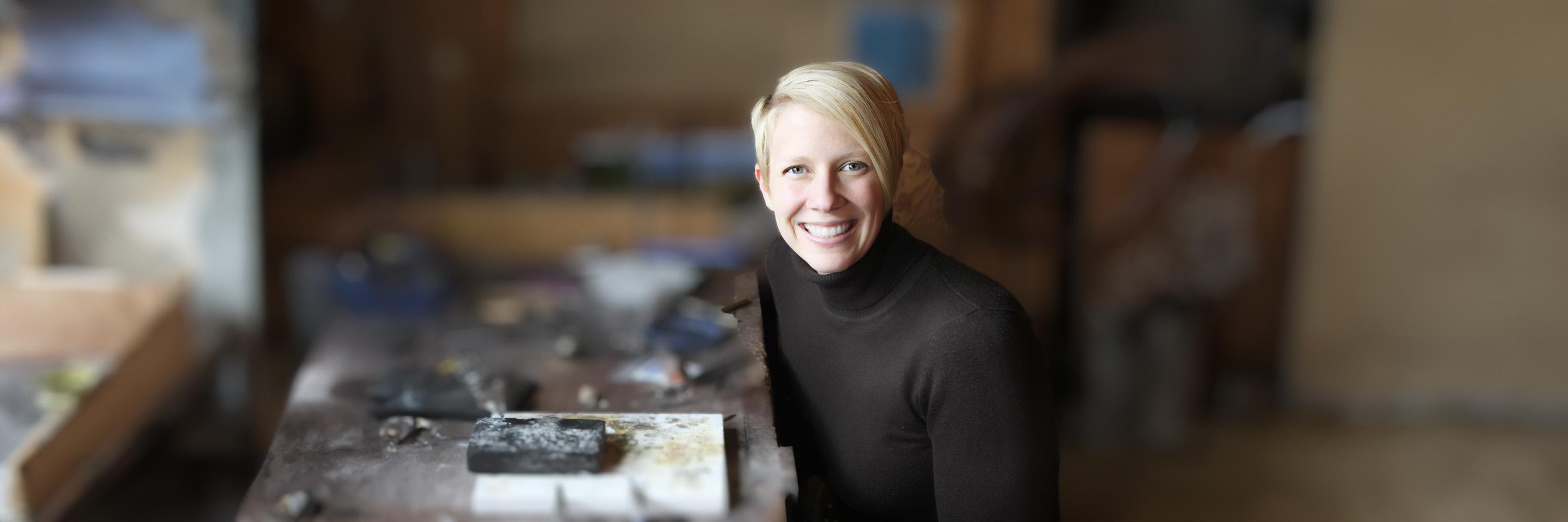 A photograph of a Apple Health client (female) sitting at her craft table with jewelry-making tools. 