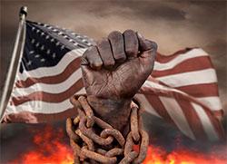 Art piece of dark, metal raised fist with chains around the wrists, an American flag flying in the background and flames at the bottom.